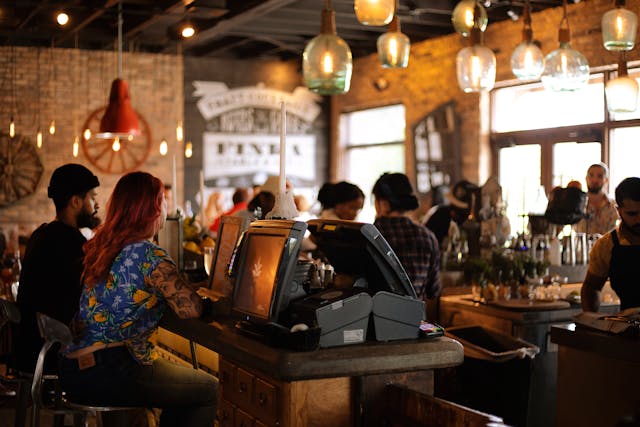 Personas conversando en interior de cafetería con estilo industrial