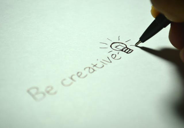 Frase “Be creative” escrita a mano con ícono de bombilla