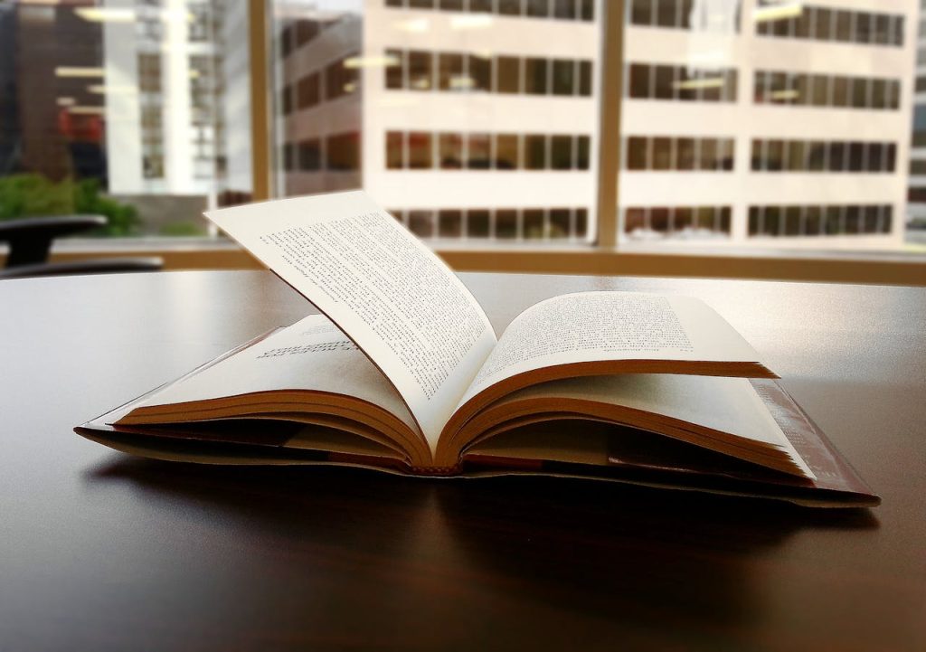 Libro abierto sobre mesa con fondo de edificios