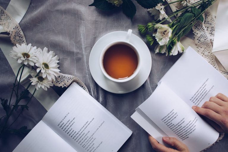 Escena relajante con libros abiertos, flores y taza de té